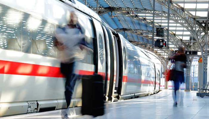 Passagiere am Bahnsteig gehen am Zug entlang